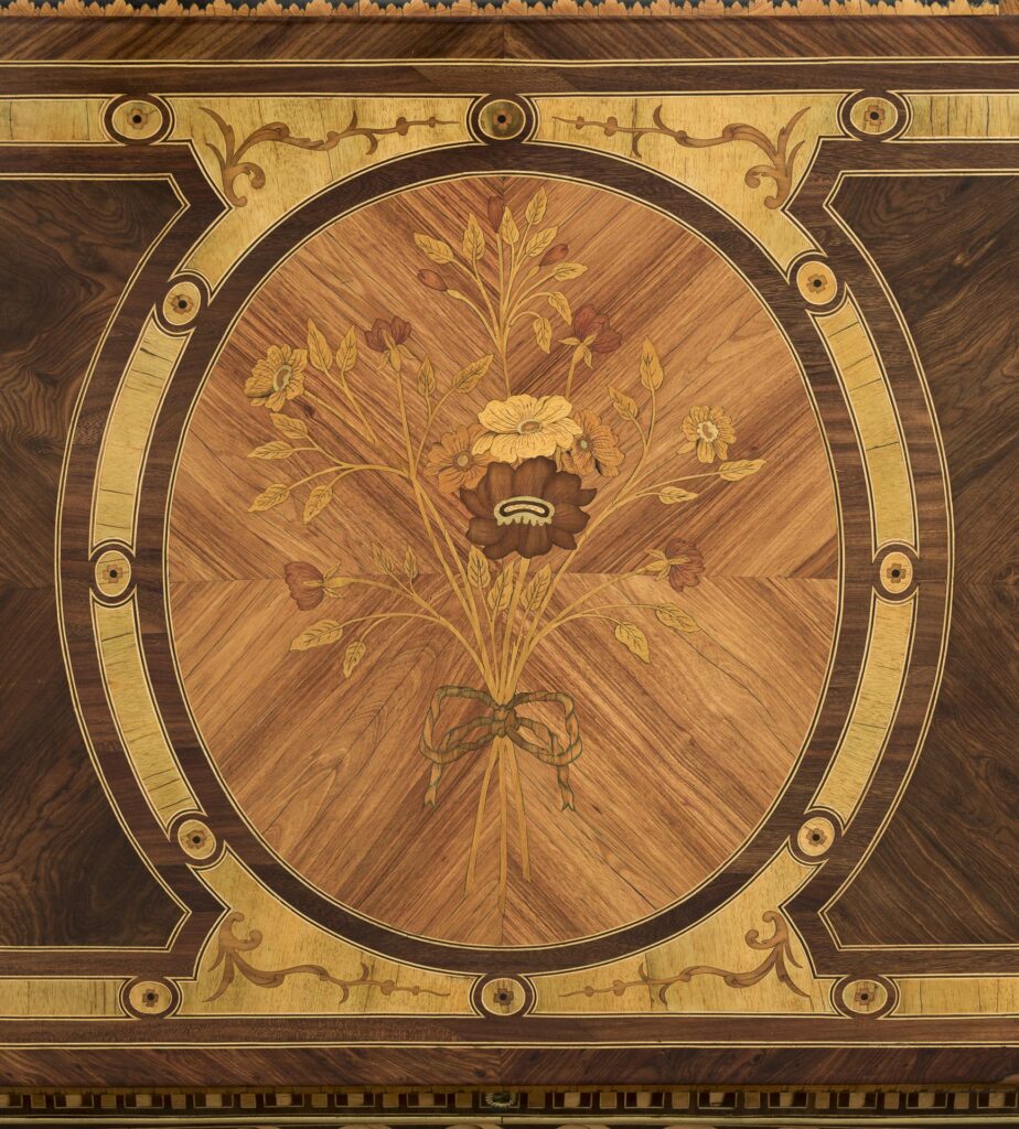 Ein Detail des Möbels mit aufwendiger Marketerie.