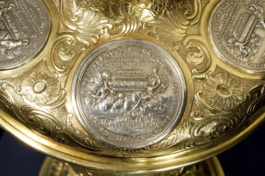 Zu sehen ist ein Detail des Deckelpokals: Die Verzierung mit einer Münze.