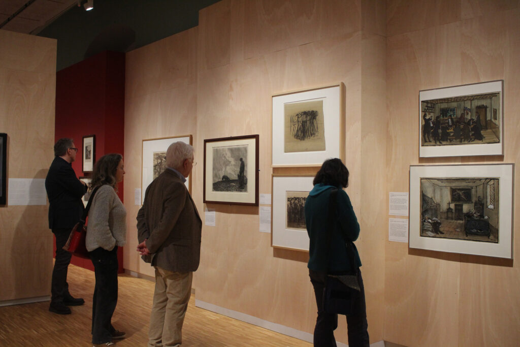 Mehrere Personen schauen sich Werke der Ausstellung an.