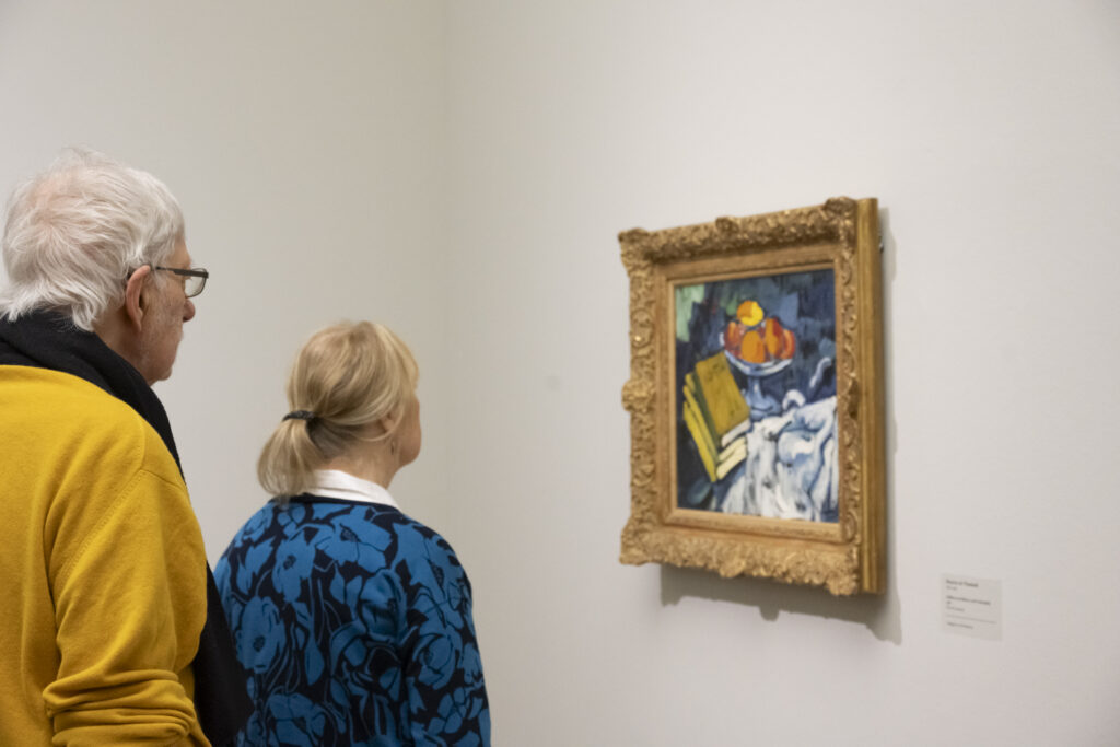 Zwei Personen betrachten ein Stillleben von Maurice de Vlaminck.