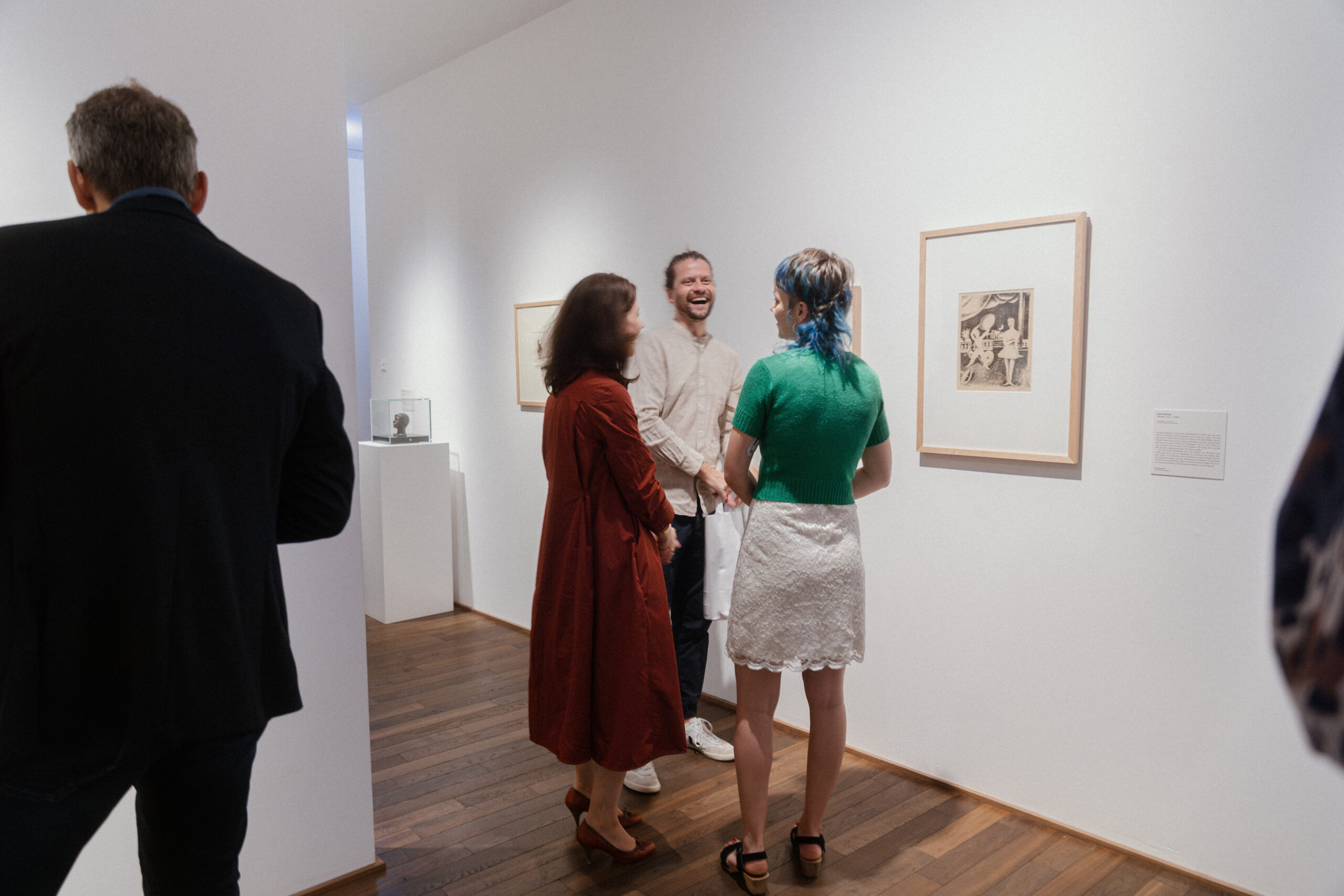 Eine Gruppe von Personen unterhält sich in der Ausstellung.