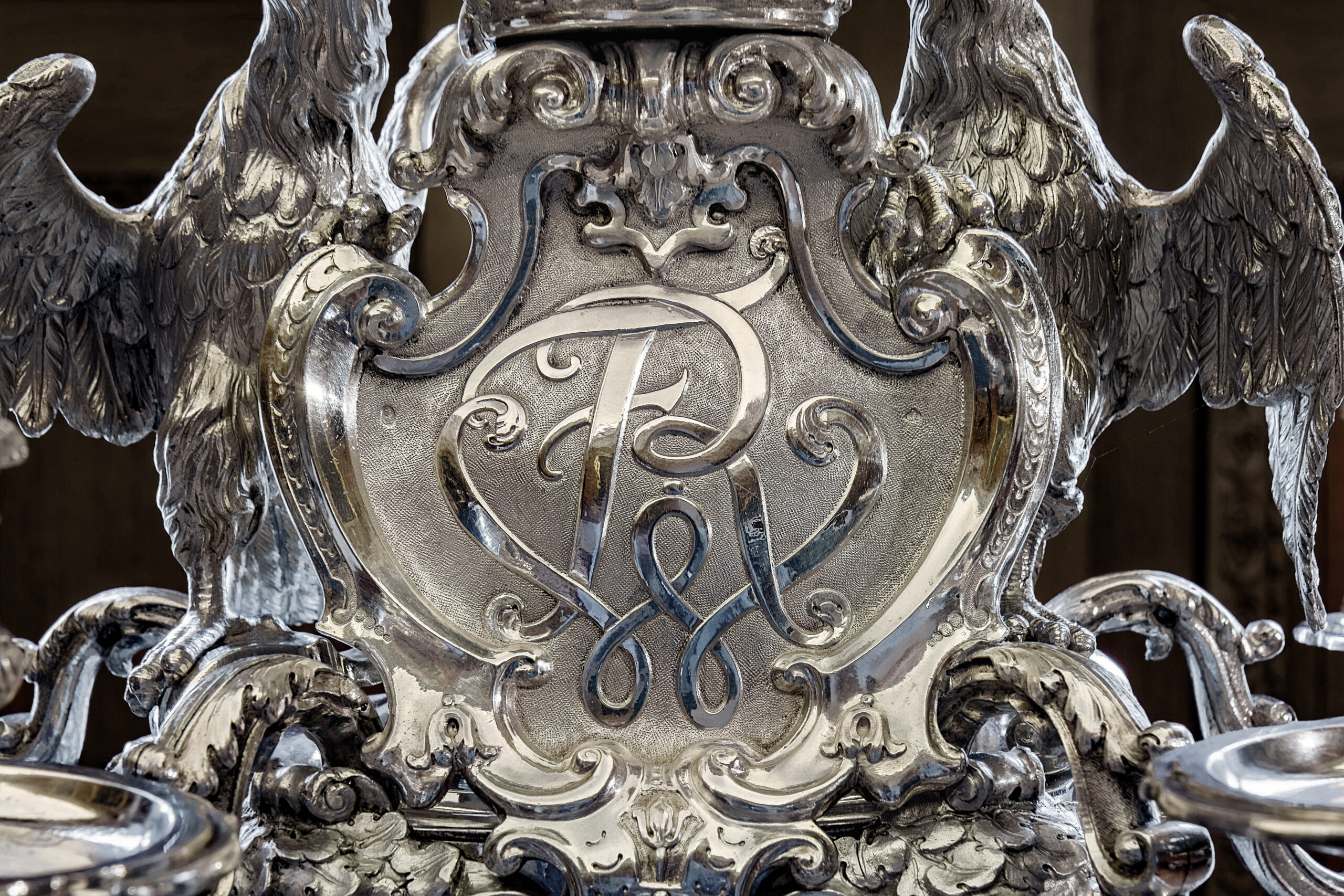 Zu sehen ist ein Detail des Silber-Leuchters mit einer Kartusche, die die Initialen FWR für Friedrich Wilhelm Rex zeigt.