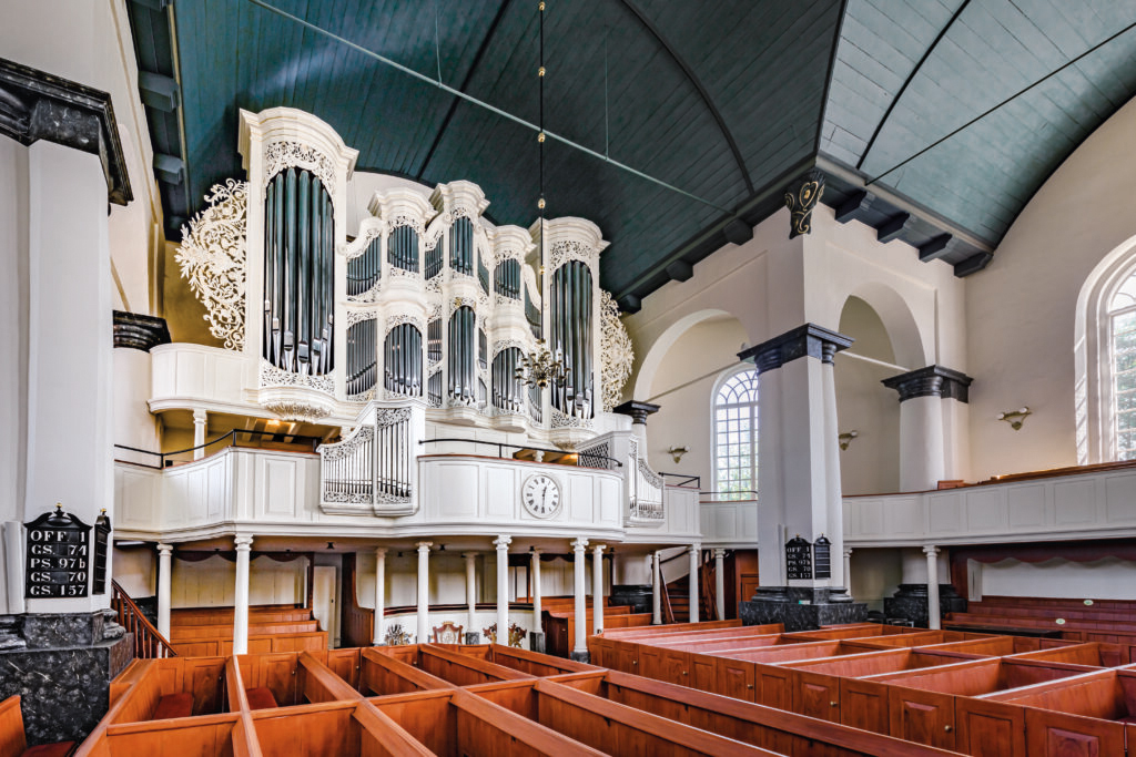 Zu sehen ist der Innenraum der Kirche mit Blick zur prunkvollen Orgel.