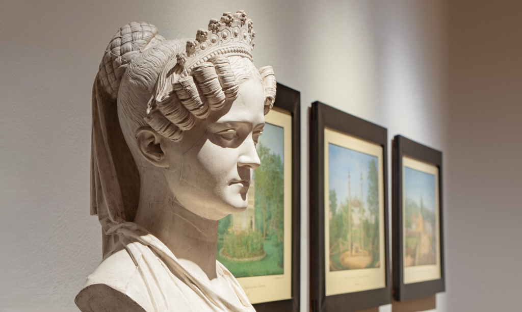 Zu sehe ist eine Ausstellungsansicht mit einer Büste der Großherzogin Wilhelmine von Hessen und bei Rhein im Vordergrund.